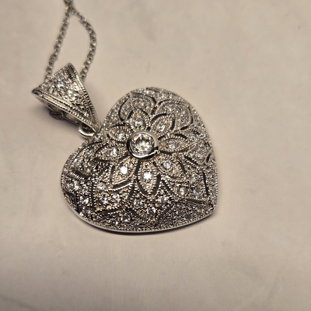 Silver, heart shaped pendant with cubic zirconia diamond.